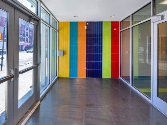 The preschool’s lobby entrance with a multi-color wall and large glass windows.