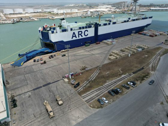 An aerial view of a ship docked at a berth for loading.