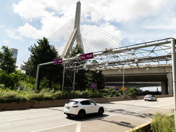 A vehicle travels under a toll collection point.