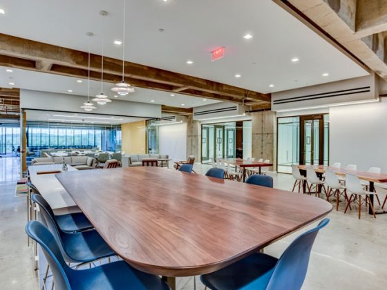 Blue chairs surround a large wooden conference table.