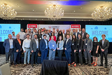 Gannett Fleming 2024 Innovation Summit attendees smile for a group photo while gathered to discuss innovation in the AEC industry.