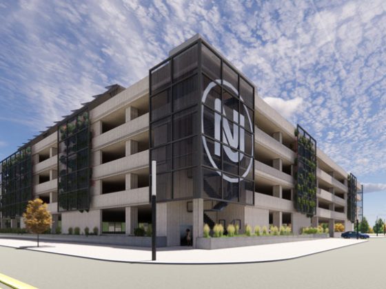 Image of a tan parking garage with a black NJ logo.